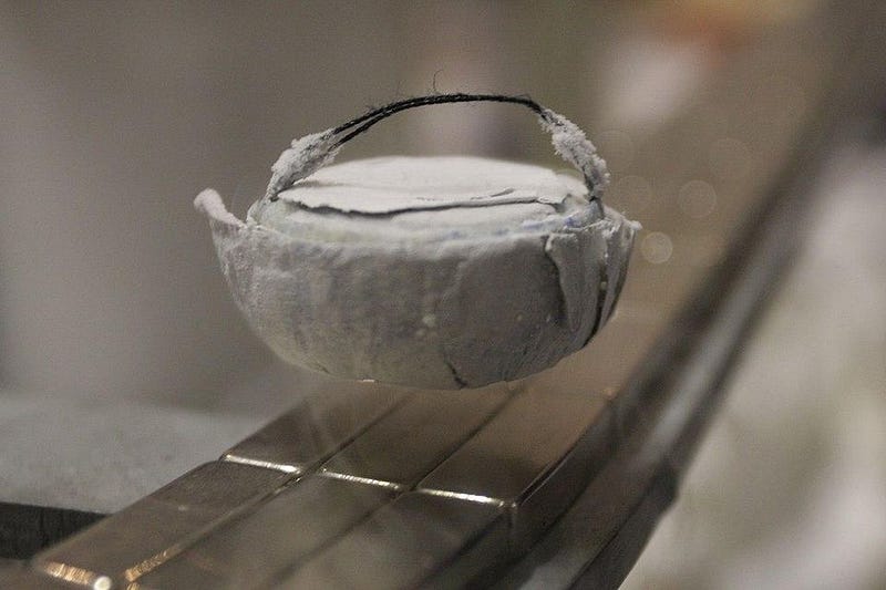 Type II superconductor levitating above magnetic tracks